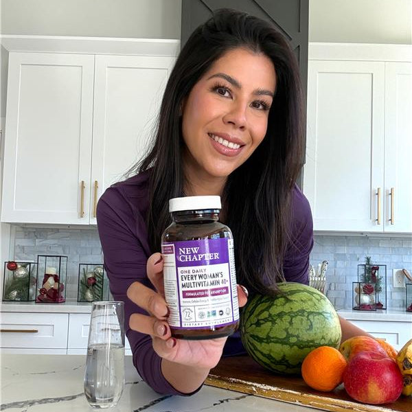 woman holding our every woman one daily multivitamin 40+ 